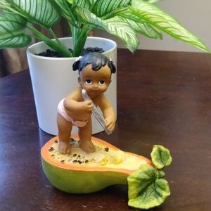 Adorable baby girl on a Papaya figurine